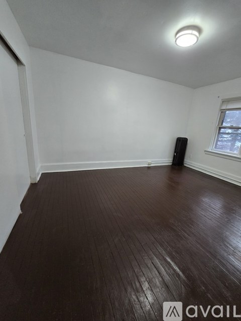 A room with wooden flooring and a window.