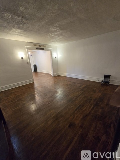 A room with wooden floors and a white wall with a sign that says "Walnut Grove".