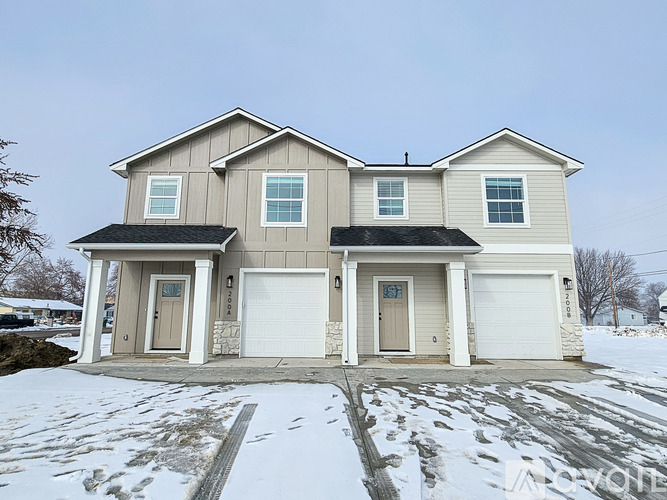 A house with a grey roof and white garage doors.