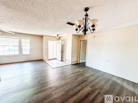 A room with wooden floors and a chandelier.