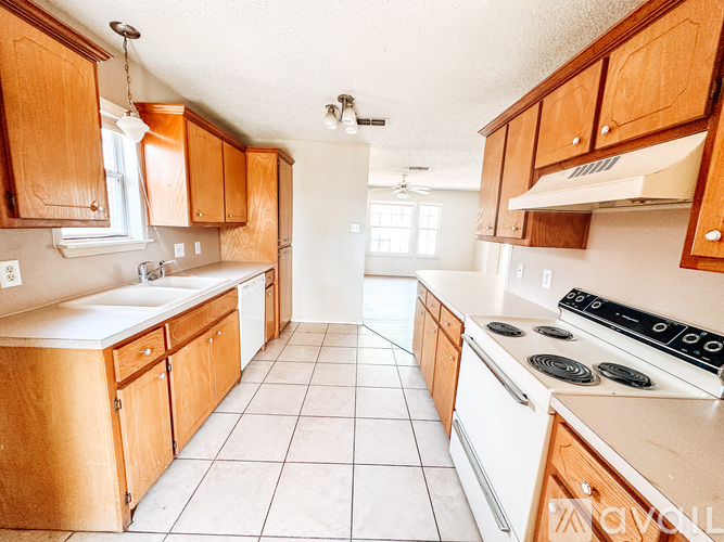 A kitchen with wooden cabinets and white appliances.