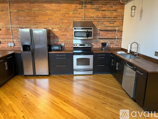 A kitchen with a refrigerator, oven, and sink.