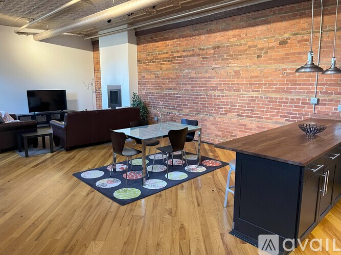 A living room with a brick wall and a wooden floor.