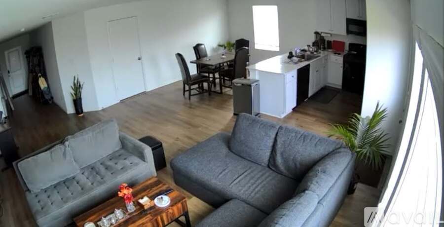 A modern living room with a grey sofa and a television displaying a login screen.