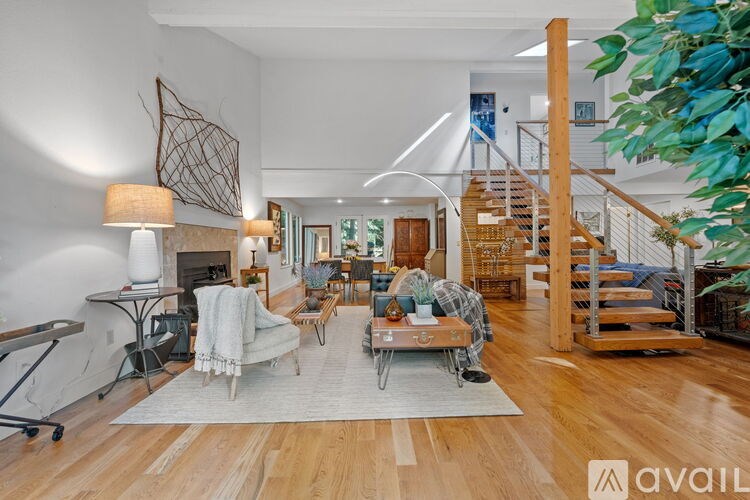 A living room with a wooden floor and a staircase.
