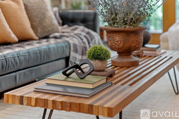 A wooden table with a pair of glasses and a plant on it.