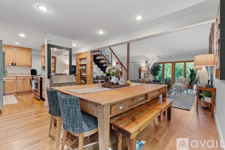 A wooden dining table with chairs and a bench in a well-lit room.