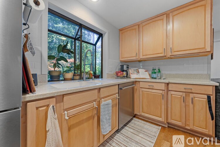 A kitchen with wooden cabinets and a stainless steel refrigerator.