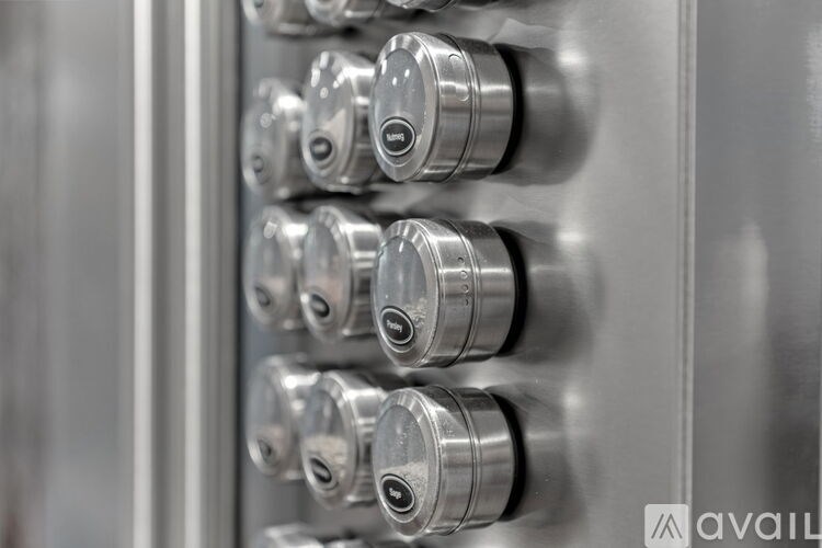 A row of metallic cylinders are mounted on a wall.