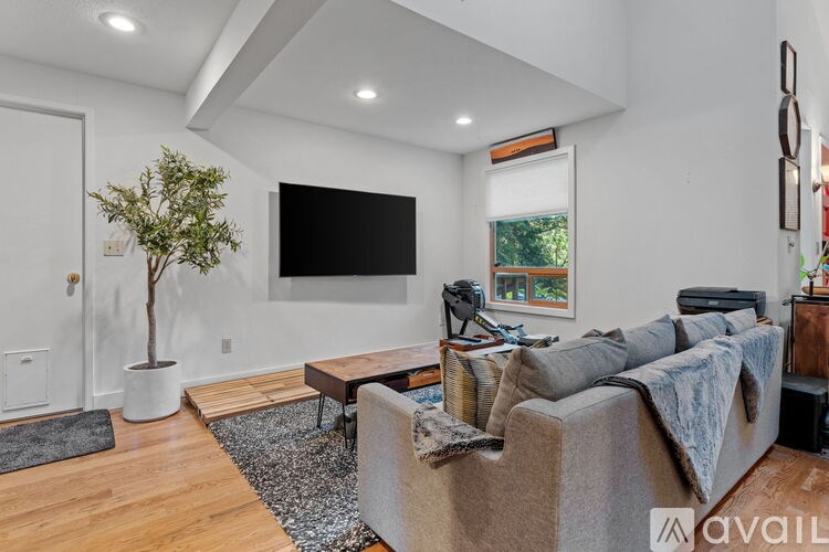 A living room with a grey couch and a wooden coffee table.
