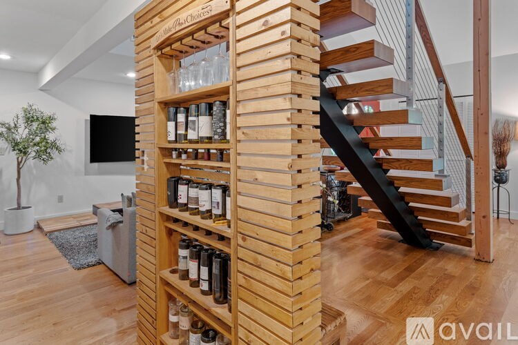 A wooden shelf with bottles and glasses on it.