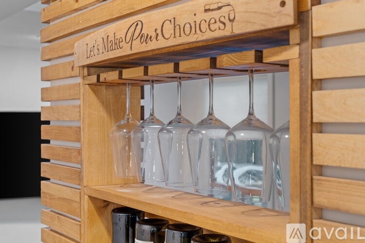 A wooden shelf with glasses and a sign that says "Let's Make Pour Choices".