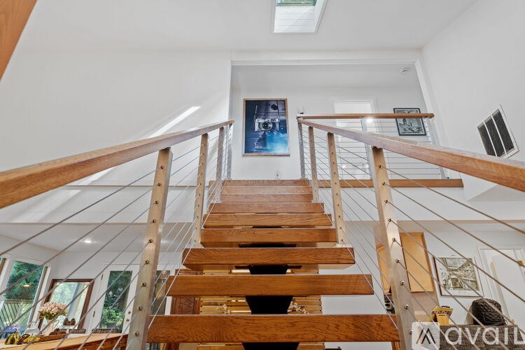 A wooden staircase with a skylight above it.