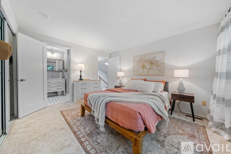 A bedroom with a bed, nightstand, and a rug.