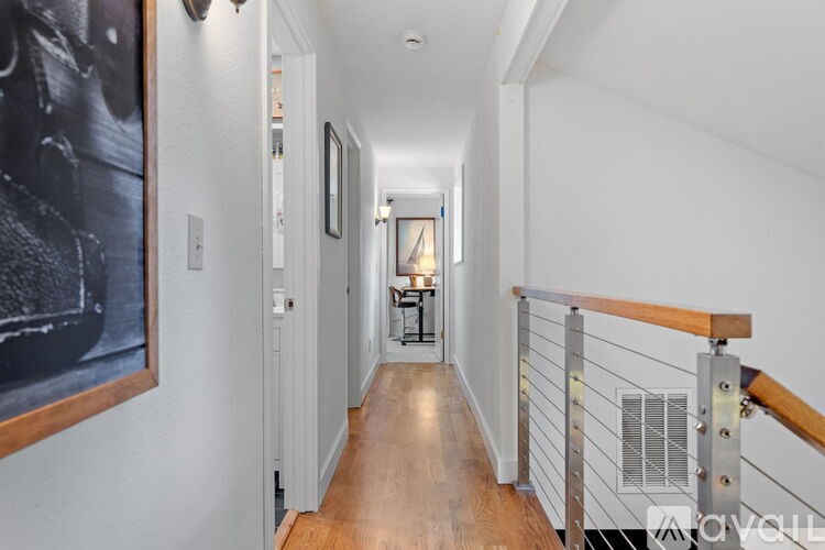 A long hallway with a wooden floor and a metal railing.