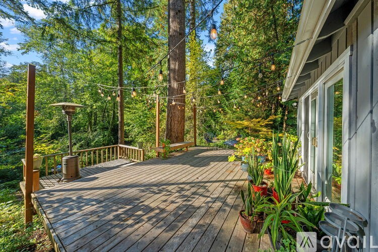 A wooden deck with a bench and potted plants.