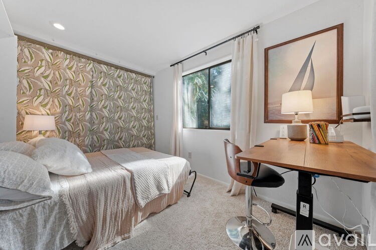 A bedroom with a bed, desk, and chair.