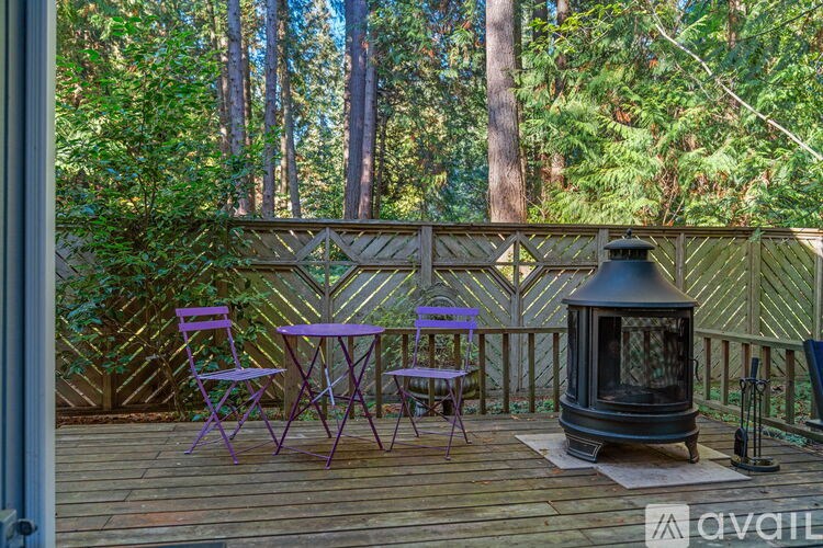 A wooden deck with a table and chairs and a lantern.