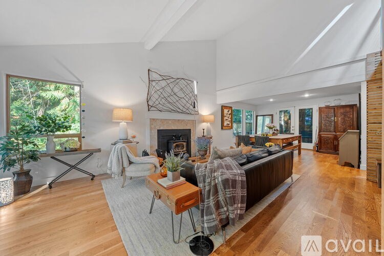 A modern living room with a fireplace and a large window.