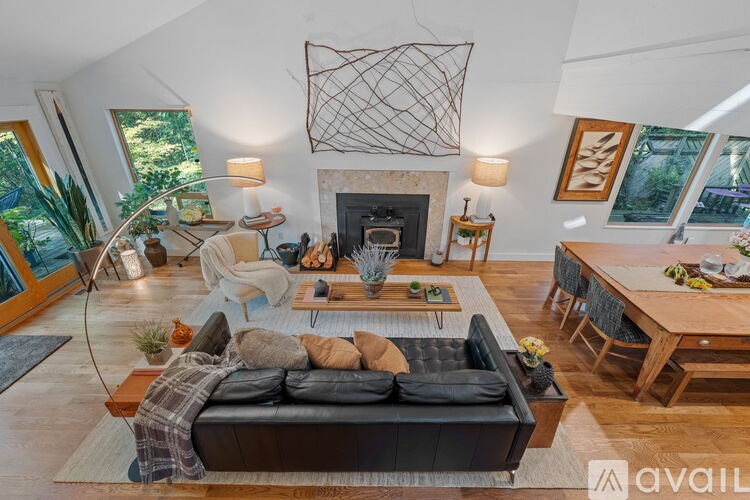 A living room with a black couch and a fireplace.