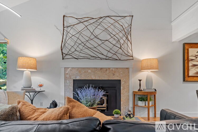 A living room with a fireplace and a large piece of artwork above it.