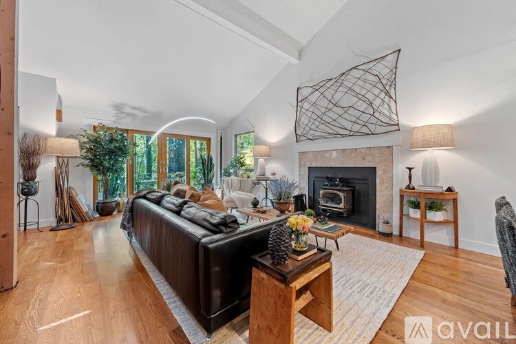 A living room with a black couch and a fireplace.