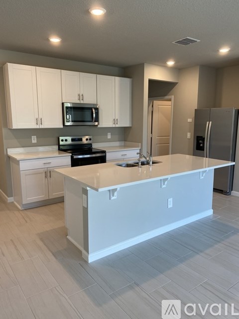 A kitchen with white cabinets and a large island.
