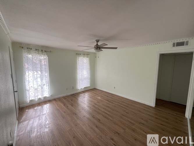 A room with wooden flooring and a ceiling fan.