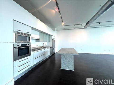 A modern kitchen with white cabinets and stainless steel appliances.