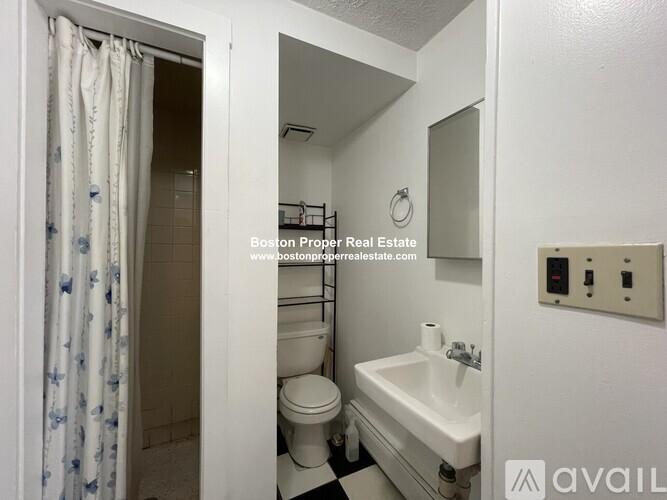A bathroom with a toilet, sink, and mirror.
