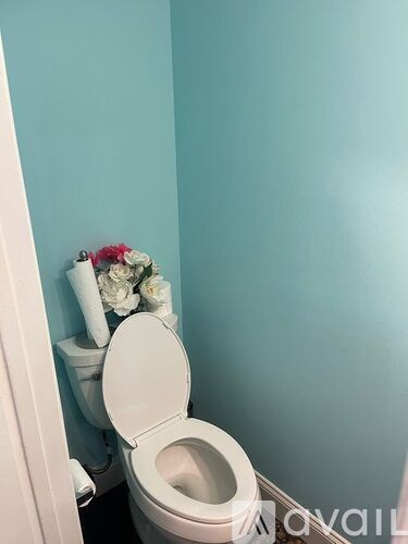 A toilet with a white seat and lid is in a room with blue walls.