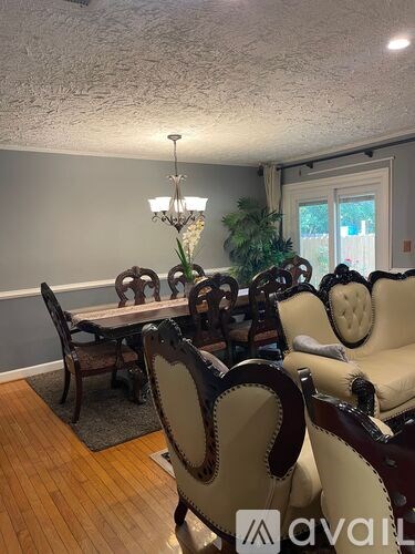 A dining room with a table and chairs.