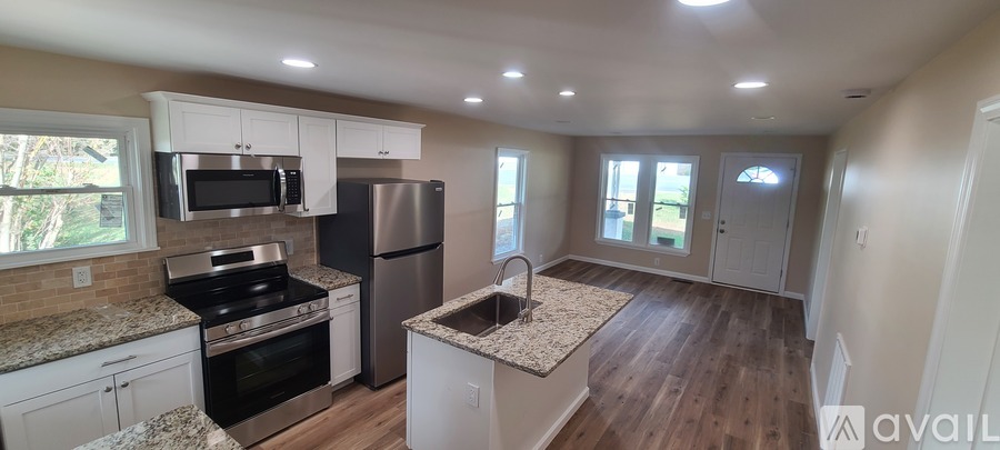 A kitchen with white cabinets and a granite countertop.