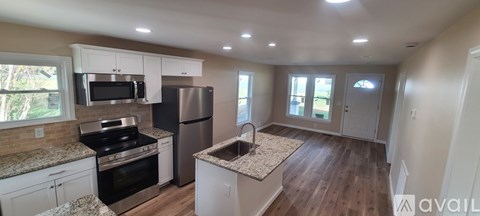 A kitchen with white cabinets and a granite countertop.