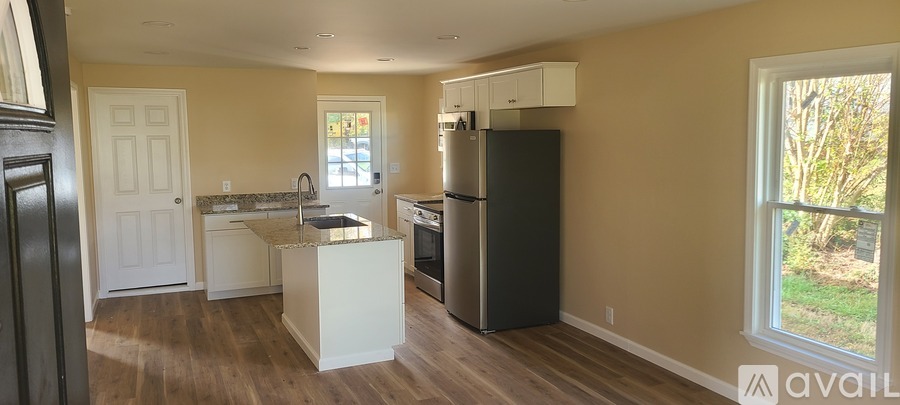 A kitchen with a black refrigerator and a white island.