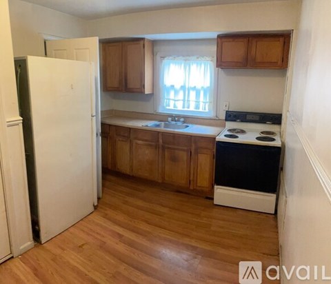 A kitchen with wooden cabinets and a white fridge.