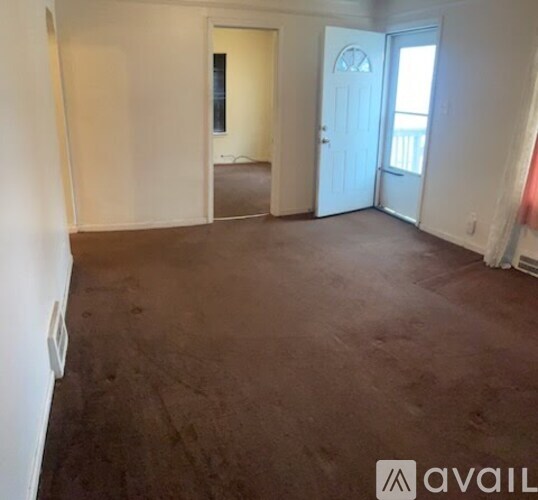 A room with brown carpet and white walls.