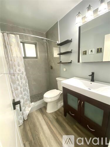 A bathroom with a toilet, sink, and shower.