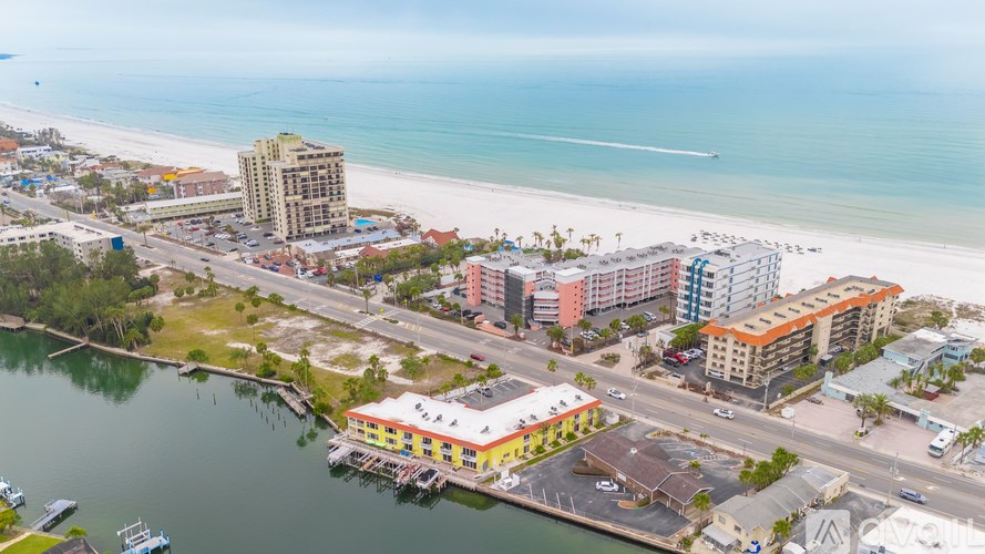 A beachfront area with a pier and buildings.