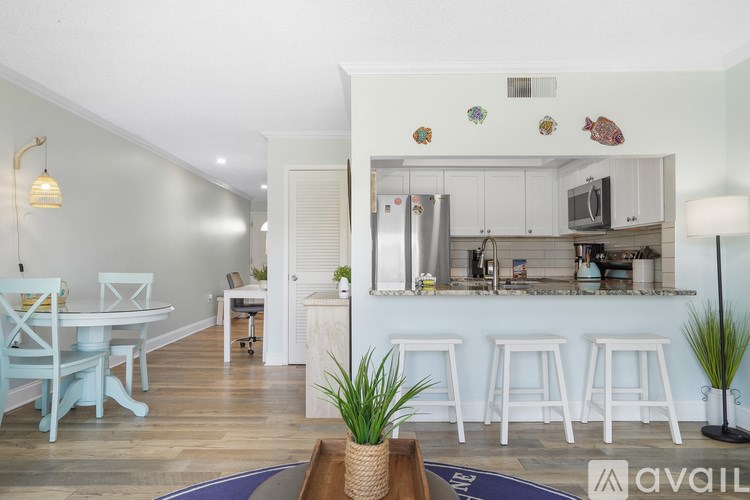 A kitchen with white cabinets and a white table with chairs.