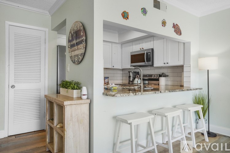 A kitchen with white cabinets and a wooden island.