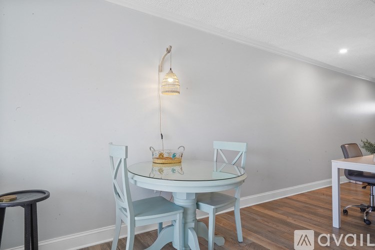 A dining table with chairs and a hanging light fixture.