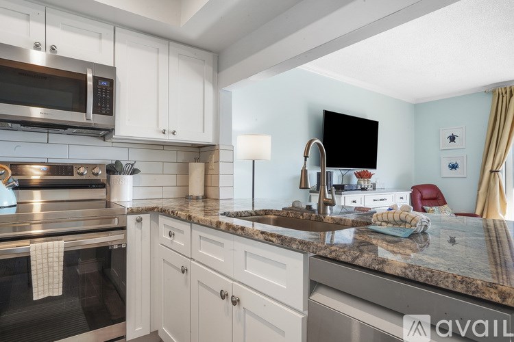 A kitchen with granite countertops and white cabinets.