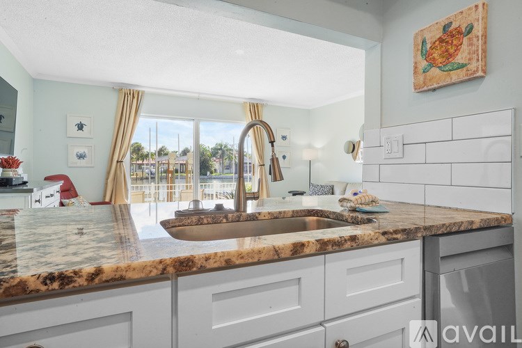 A kitchen with a marble countertop and a view of the outside.