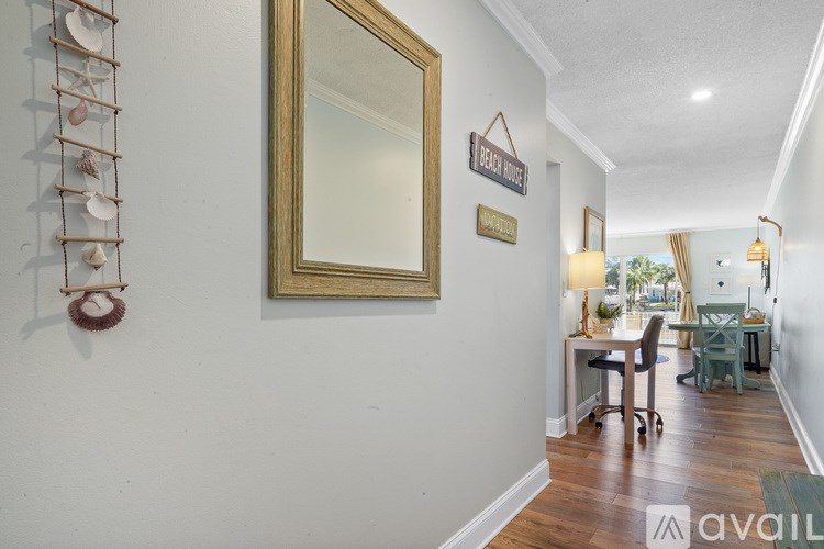 A hallway with a mirror, a sign that says "Pretty Place", and a wall with shells on it.