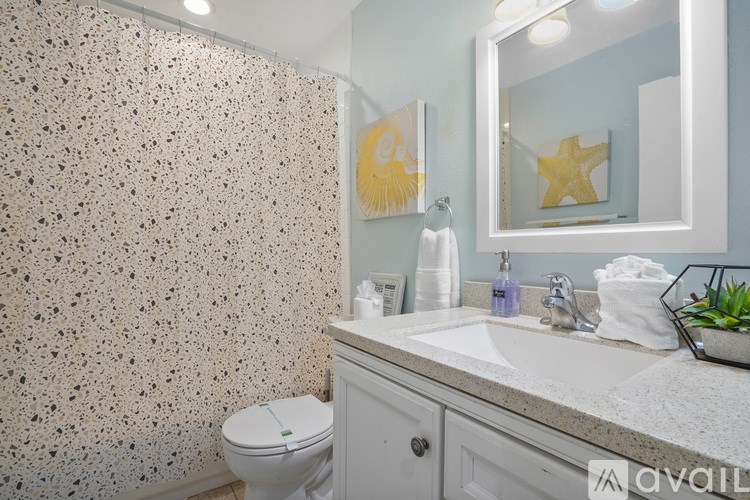 A bathroom with a toilet, sink, and a mirror.