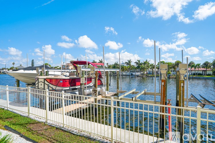A boat is docked at a marina with a red canopy.