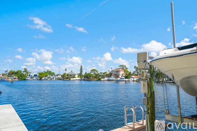 A boat is docked on a calm body of water with a clear blue sky above.