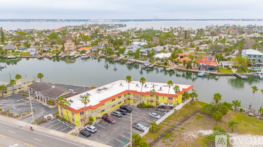 A parking lot with a building in front of a body of water.