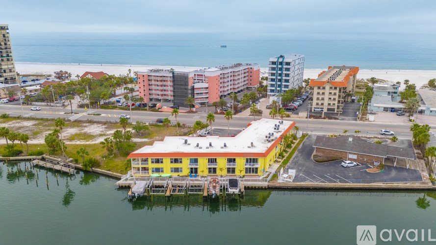 A yellow building with a red roof is situated on the waterfront.